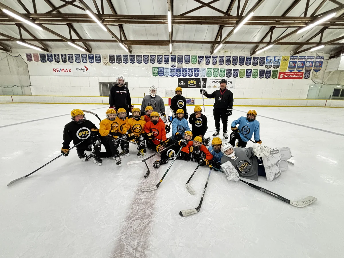 BWC U11 A1 Team with coaches on the ice at Burnaby Winter Club